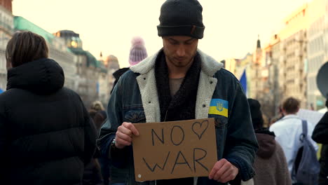 protester with placard at demonstration against war in ukraine, prague