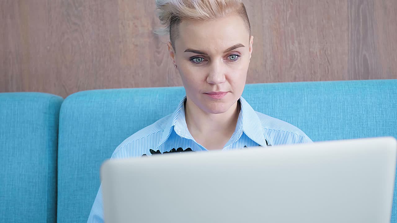 Woman Working on Laptop in a Cafe