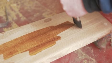 brushing danish oil onto sapele timber plank