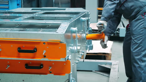 workman working with t-shape wrench during assembly of industrial machine