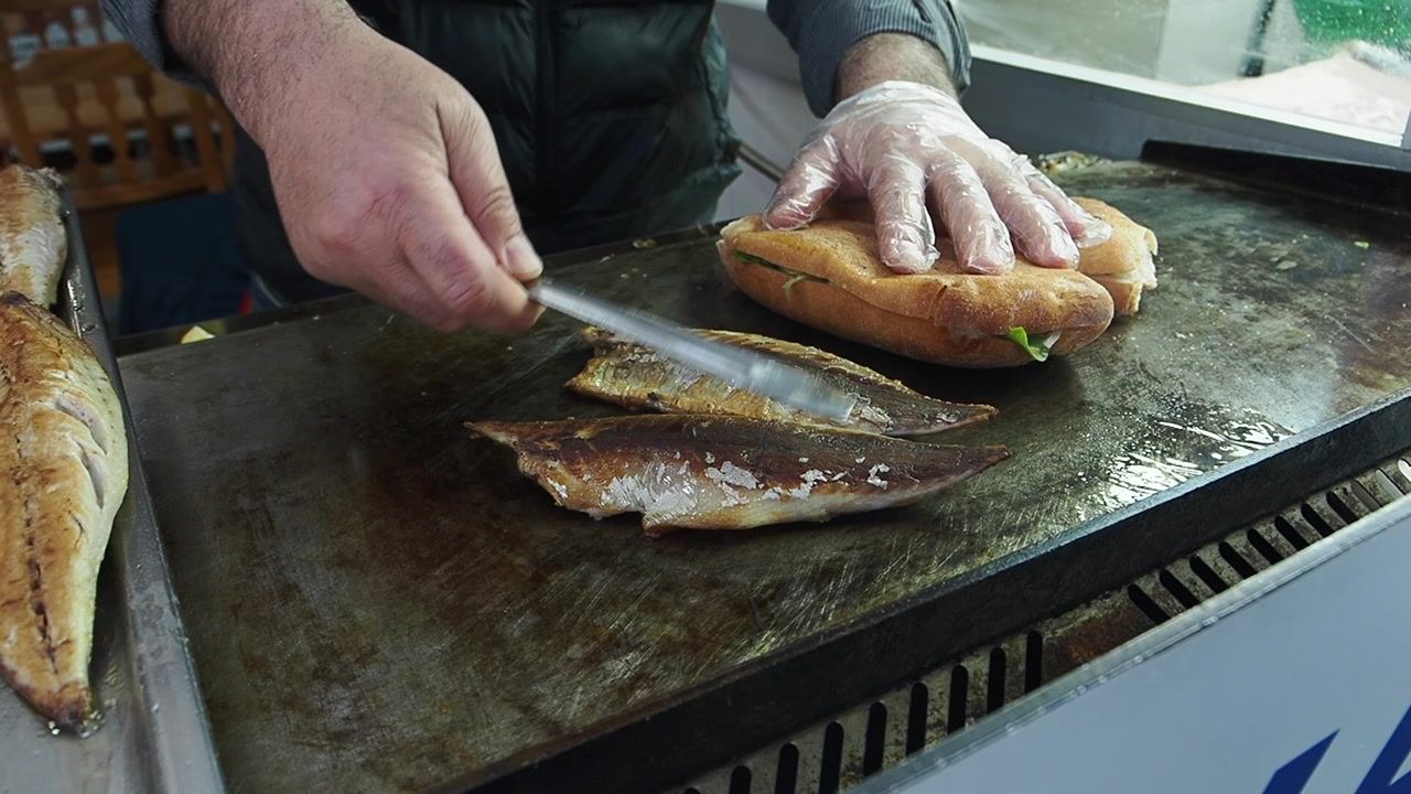 Chef Preparing Fresh Grilled Fish Sandwich on a Hot Griddle