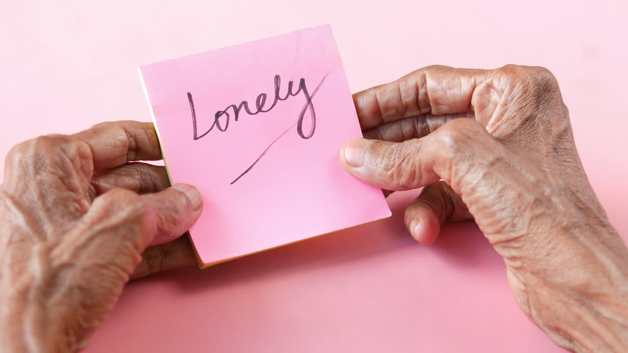 고독 한 노인 들 의 손 들 이 붙여진 메모 를 들고 있다