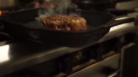 slowmo - close up - chef putting a bbq grill pan with a steak into the oven