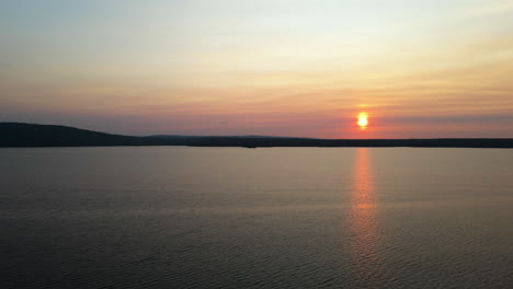 aerial shot of orange sunset over a calm lake in canadian cottage country. calabogie ontario