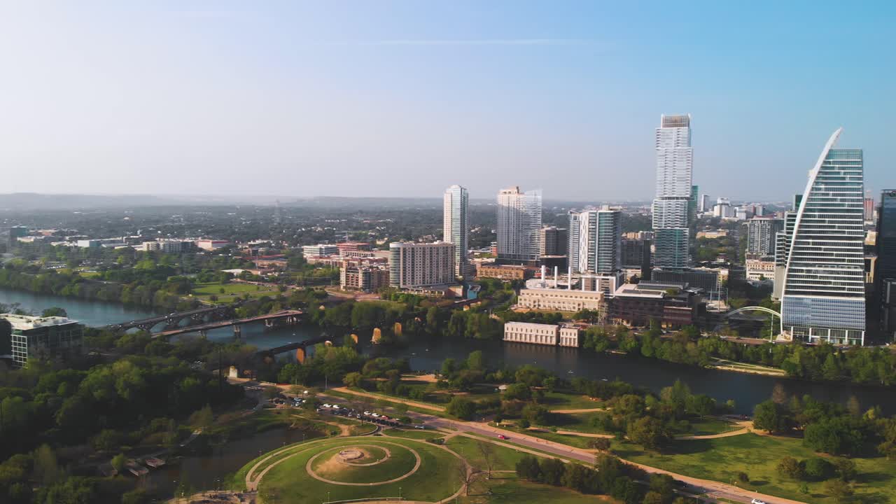 Splendida ripresa panoramica a 360 gradi, vista aerea 4K del centro di Austin, TX, con grattacieli, Lady Bird Lake, Congress Bridge e Zilker Park in una giornata di sole