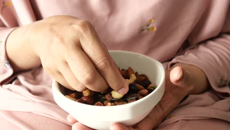 woman eating a mix of nuts and raisins