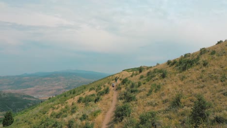 hikers continue on walking to climb the top of the mountain in park city utah