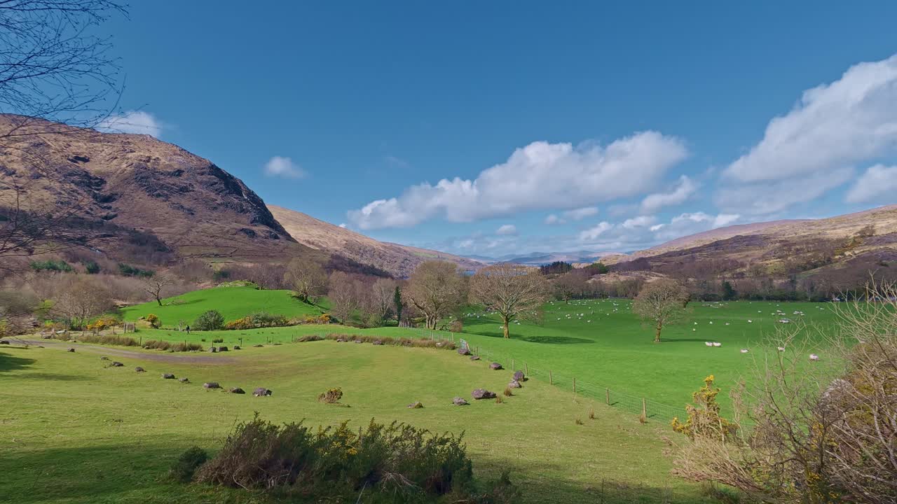 Wiejski krajobraz irlandzki, kamienny krąg na łące w cieniu gór, Kerry, Irlandia, epickie lokalizacje.