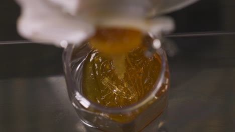 honey is poured into a jar from above