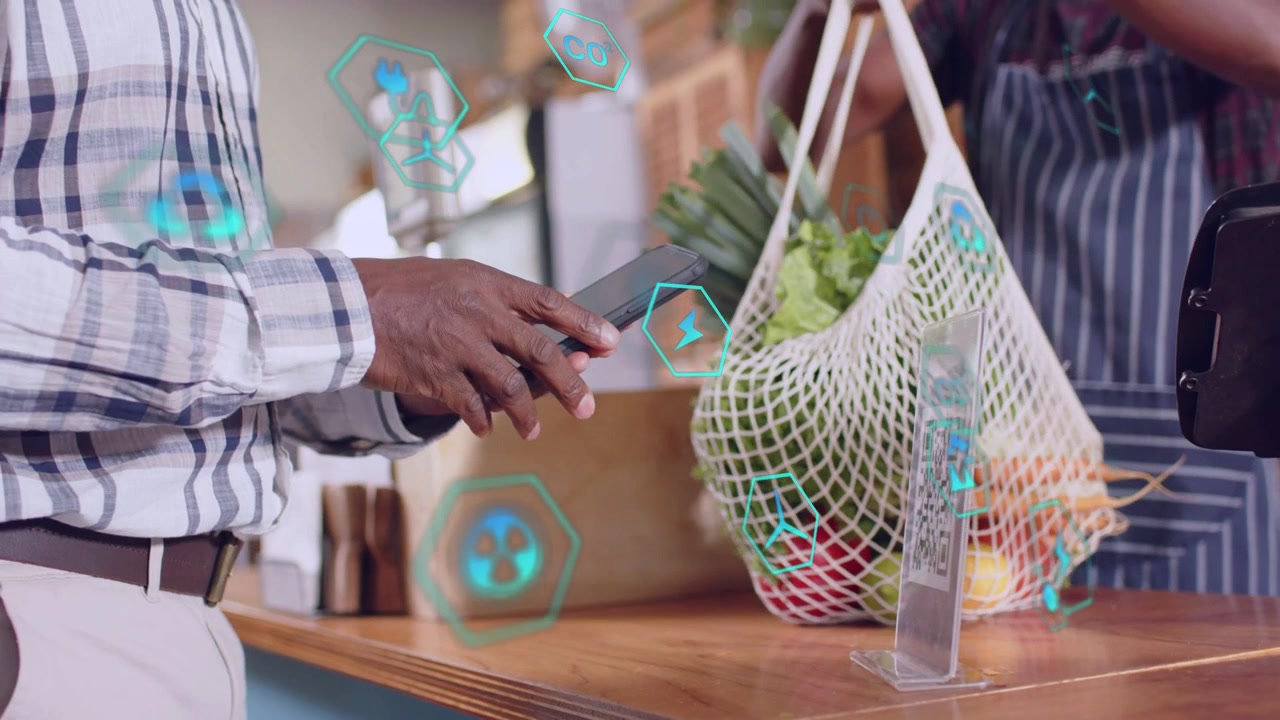 Customer tapping phone, starting mobile pay, teal UI animating around phone as cashier handing bag