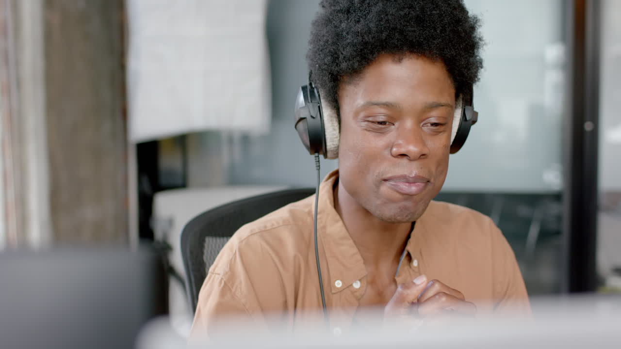 Uomo afroamericano felice con le cuffie che parla durante un podcast dal vivo, spazio per il testo, al rallentatore