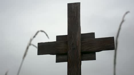 wooden cross in the rain on a cloudy day close up perspective shot