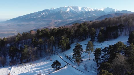 aerial drone shot mount olympus forest foreground winter snow panning left