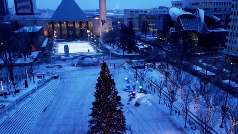 edmonton city hall plaza sir winston churchill square station christmas tree decorated lit dolly roll rise winter snow covered grounds ice skating rink ready for use at the modern pyramid structure