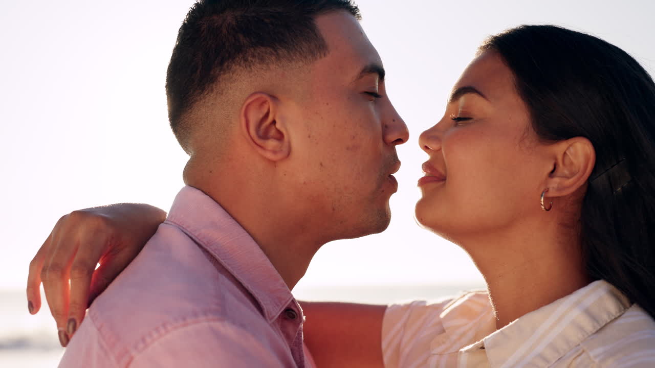 Amore, tramonto e una coppia che si bacia sulla spiaggia