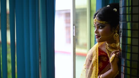 romantic and thoughtful indian bride looking outside the window at evening