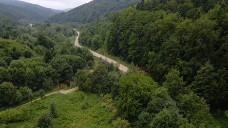 aerial view of a road in the carpathian mountains, cloudy day, in ukraine - dolly, drone shot
