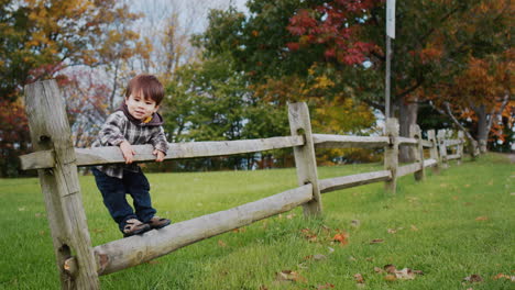 A-cheerful-Asian-kid-climbed-on-a-fence-near-the-farm.