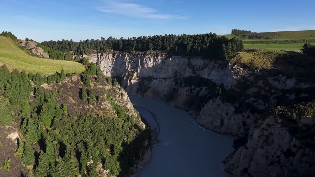 espectacular acantilado geológico con línea de árboles y río del desfiladero de rakaia
