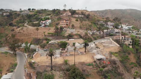 Aerial close-up panning shot of burned properties in the Las Flores neighborhood of Malibu, California after the Palisades Fire. 4K