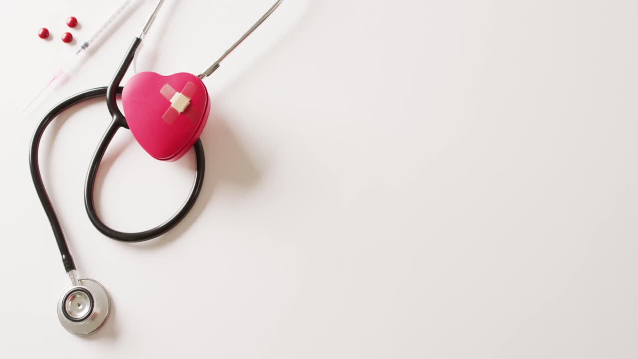 video de corazón rojo con parches pegajosos, estetoscopio, jeringa y píldoras, en blanco con espacio para copiar