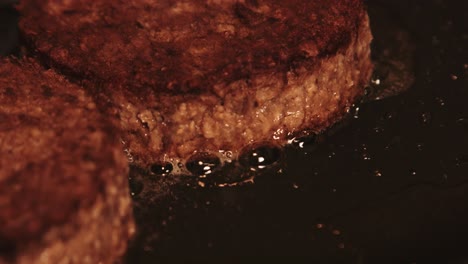 close up of delicious plantbased burgers cooking in pan