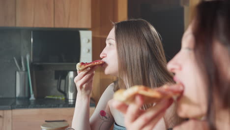 young girls in towels smiling, enjoying pizza together in a cozy indoor setting, sharing a fun and relaxed moment, captured in bright and lively lighting, having a great time