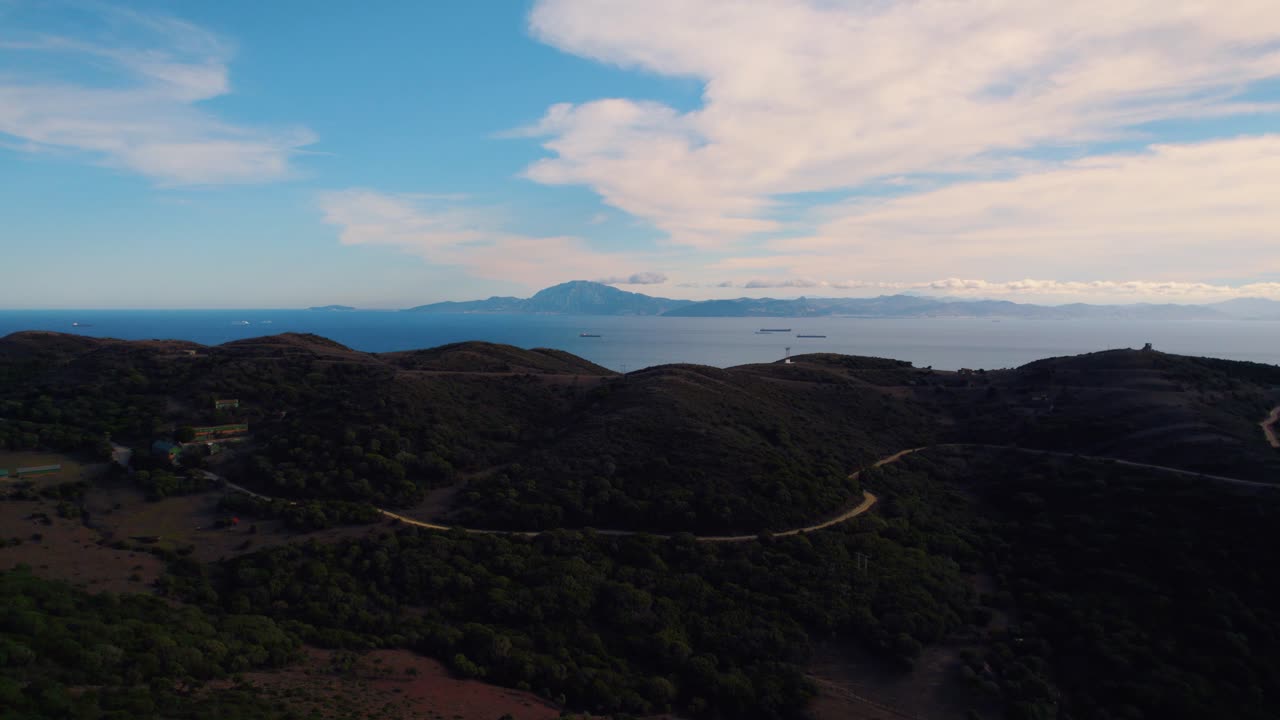 vista aérea del bosque de tarifa volando hacia el paisaje montañoso de la costa en el brumoso horizonte mediterráneo