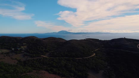 vista aérea del bosque de tarifa volando hacia el paisaje montañoso de la costa en el brumoso horizonte mediterráneo