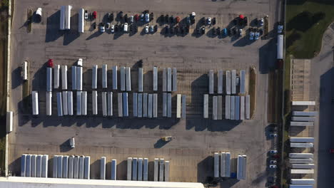 parking area with lush truck containers and cars in carriers company branch, bird’s eye view