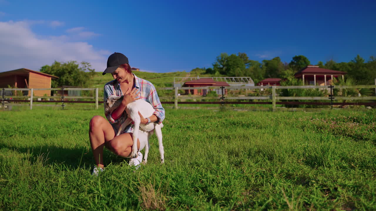 농장 에서 새끼 염소 를 들고 있는 여자