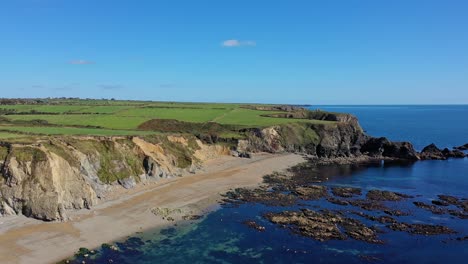 Vista-Aérea-De-La-Costa-Rocosa,-La-Playa-Y-El-Agua-Clara-En-El-Sur-De-Irlanda-En-Verano