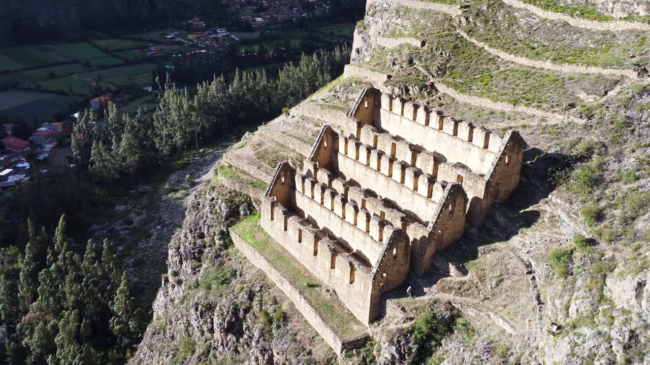 panorámica aérea de alto ángulo a la izquierda de la ciudad histórica del sitio de ollantaytambo cortado de la ladera en el peru