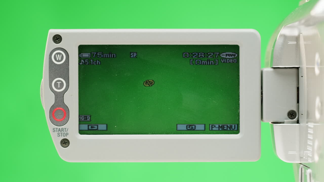 Old vintage video camera close-up. Popular retro camcorder shooting. Chroma key green screen on video-camera monitor.