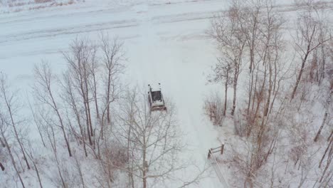 clearing snow on a rural property with a wheeled bobcat