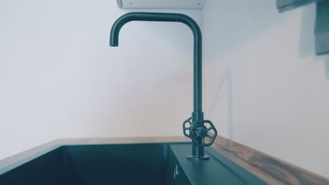 retro style faucet by sink at white wall in kitchen interior