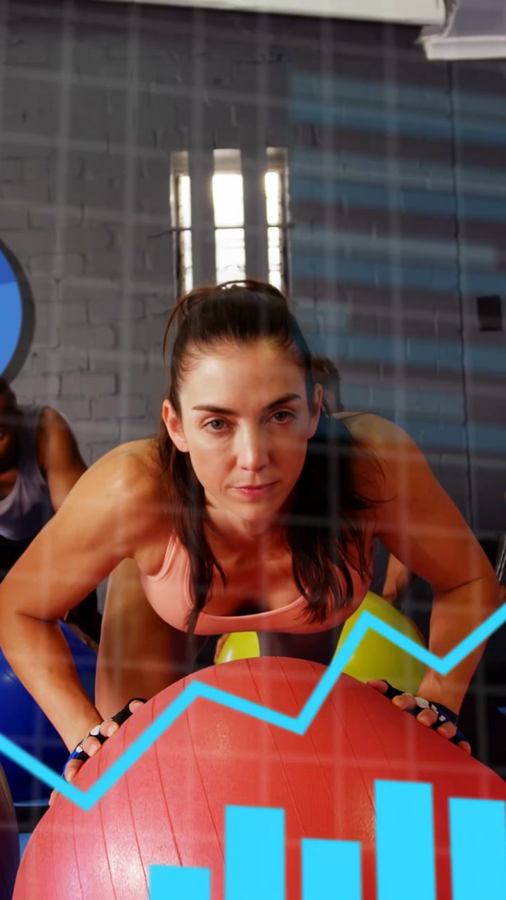 Video vertical: Mujer presionando una pelota roja en el gimnasio, cámara baja, gráficos azules y panel de datos en seguimiento.