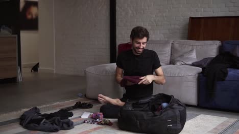 portrait of a smiling man packing his back for travel in living room