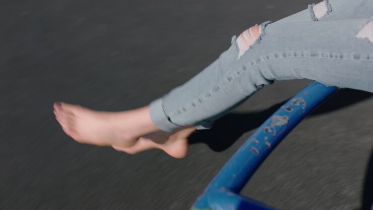 primo piano piedi donna su merry go round gambe rotanti penzolanti a piedi nudi godendosi divertimento durante le vacanze estive ragazza adolescente a piedi nudi nel cortile della scuola