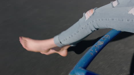 close-up-feet-woman-on-merry-go-round-spinning-legs-dangling-barefoot-enjoying-fun-on-summer-vacation-teenage-girl-barefoot-in-school-yard