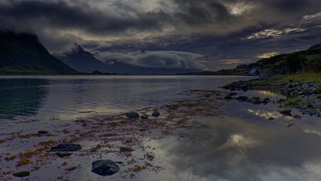 vista panorámica de bajo ángulo de un lago rodeado de montañas en una tarde nublada