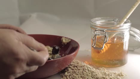 Eating-bowl-of-porridge-with-honey-and-cranberries