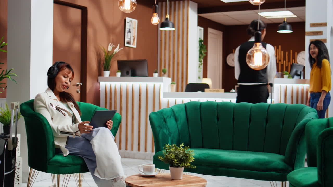 라운지 지역 로비에서 노트북에서 영화를 즐기는 아시아 클라이언트