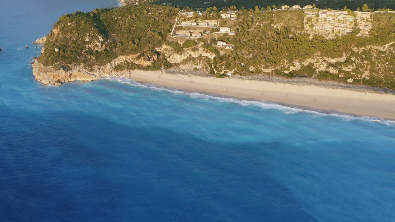 vista aérea de la hermosa playa de milos de lefkada, isla jónica, grecia. puesta de sol luz dorada y olas prístinas rompiendo el mar azul turquesa en la orilla