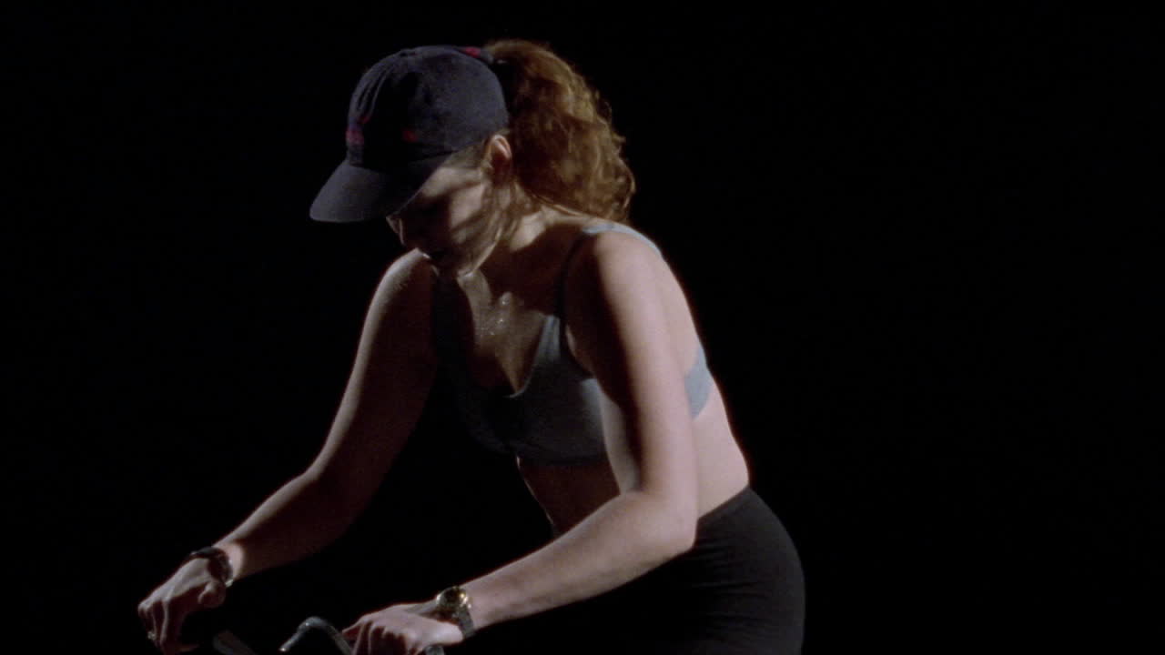 여자가 운동용 자전거를 탄다