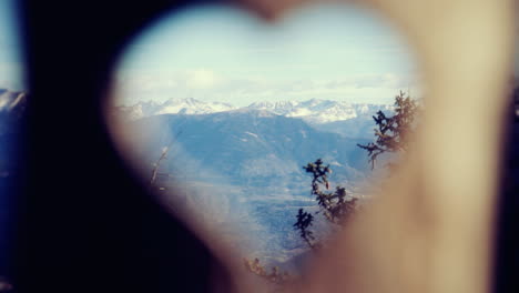 Rack-focus-handheld-shot:-from-the-shape-of-a-heart-carved-in-a-wooden-stake,-to-a-breathtaking-panorama-of-snowy-mountains-in-winter