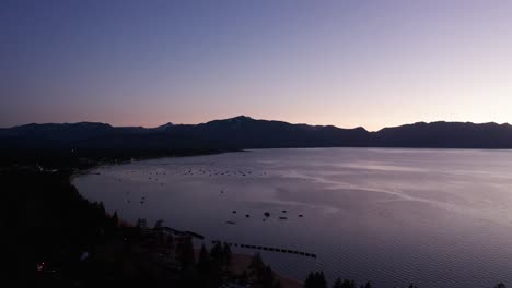 aerial shot dollying back along the shoreline of south lake tahoe at twilight