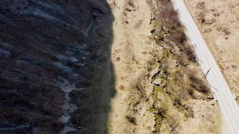 Drohnenaufnahmen-Des-Bergschattens,-Des-Kleinen-Flusses-Und-Eines-Auf-Der-Straße-Vorbeifahrenden-Autos