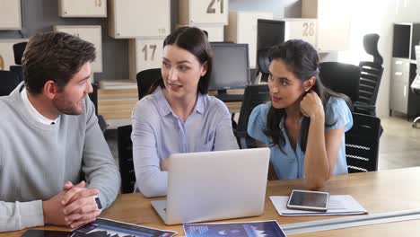 colegas de negocios discutiendo sobre una computadora portátil 4k