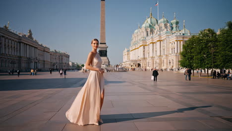 elegant woman in a long dress posing in a grand historic city square
